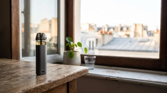 Kit de cigarette électronique simple posé sur une table en bois dans un intérieur français lumineux, symbolisant un premier pas serein vers la vape